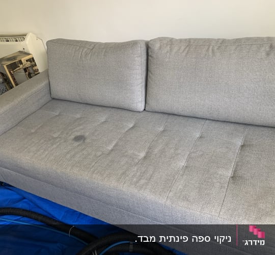 ספה אפורה עם כתמים על כיסוי כחול, צינורות ניקוי